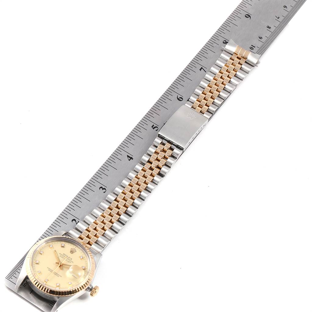 The Rolex Vintage Collection 16013 Men's Stainless Steel Champagne Dial 16013 Men's Stainless Steel Champagne Dial watch is shown laid flat with its bracelet at an angle against a measuring ruler.