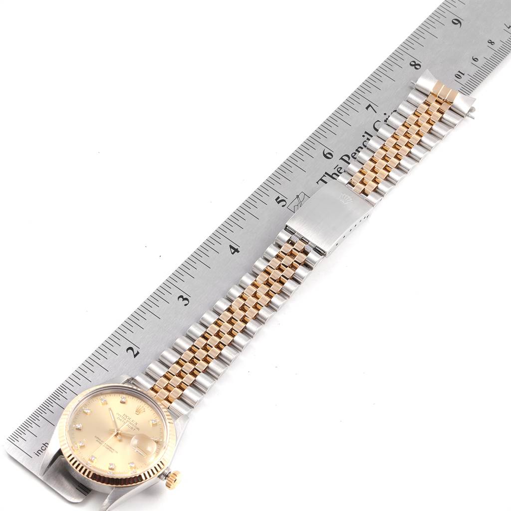 The Rolex Vintage Collection 16013 Men's Stainless Steel Champagne Dial 16013 Men's Stainless Steel Champagne Dial model is shown from top view, featuring the watch face, crown, and part of the bracelet next to a ruler.