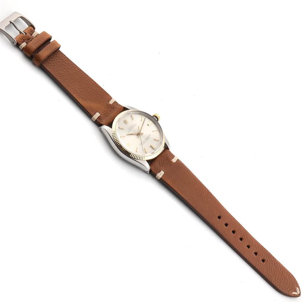 This image shows a Rolex Vintage Collection 1005 Men
s Steel and Gold (two tone) Silver Dial 1005 Men
s Steel and Gold (two tone) Silver Dial watch, viewed from an above angle, revealing its brown leather strap and silver case.