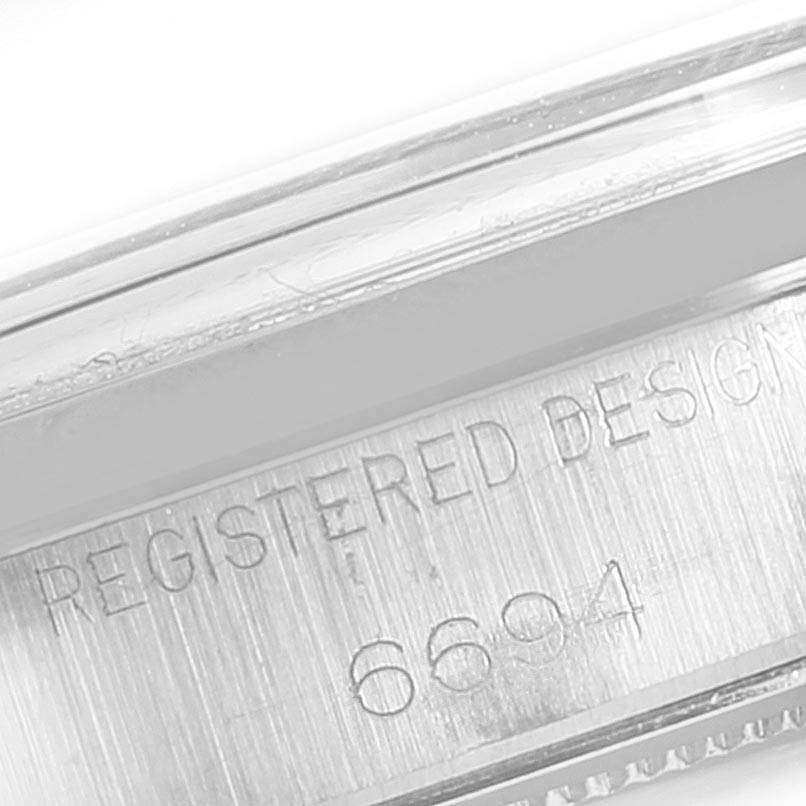 This close-up image shows the engraved serial number "6694" on the side of the case of a Rolex Vintage Collection 6694 Men's Stainless Steel Silver Dial 6694 Men's Stainless Steel Silver Dial watch.