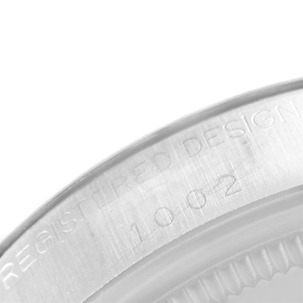The image shows a close-up of the caseback edge of a Rolex Vintage Collection 1002 Men's Stainless Steel Silver Dial 1002 Men's Stainless Steel Silver Dial model, focusing on the engraved "REGISTERED DESIGN" and model number.
