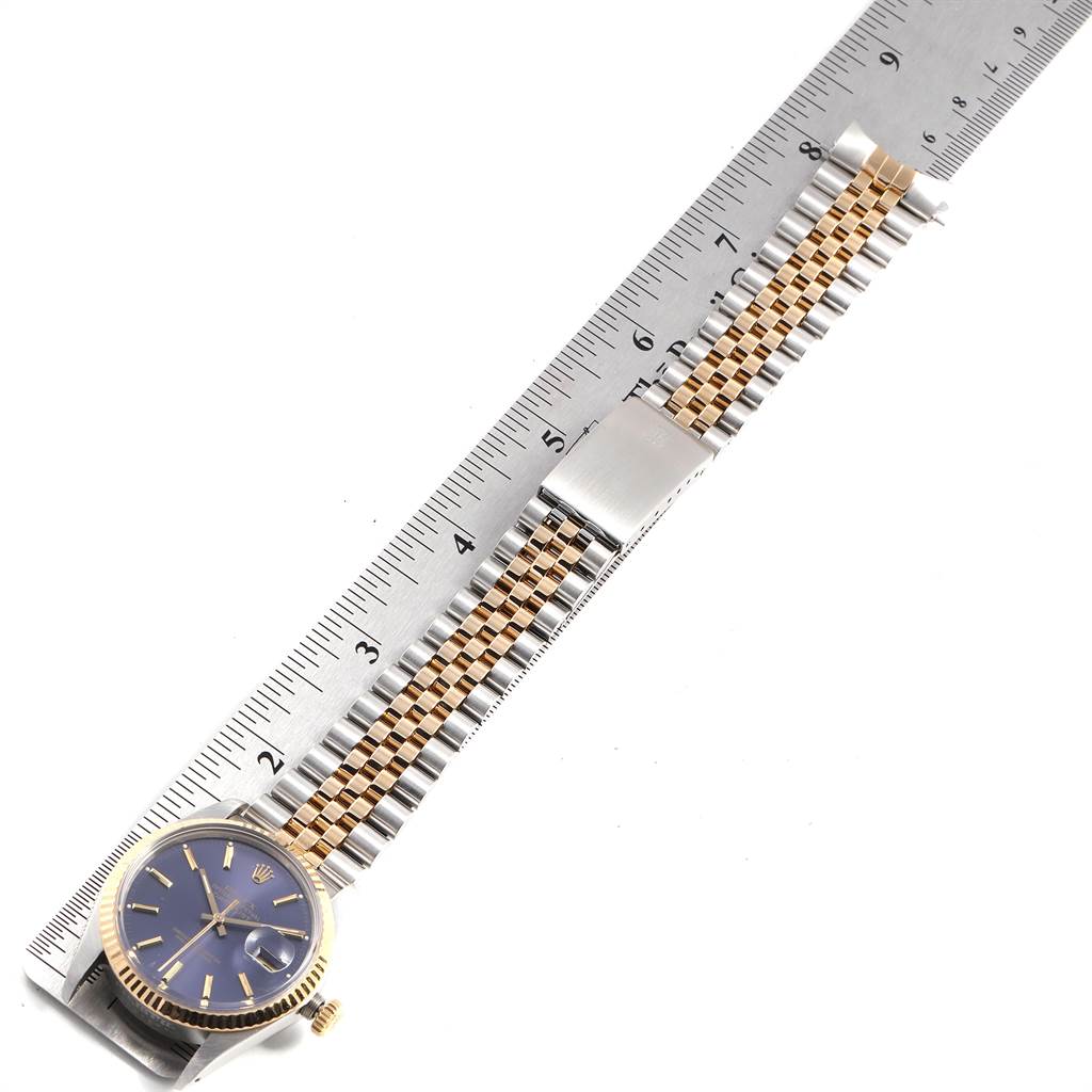 The Rolex Vintage Collection 16013 Men's Stainless Steel Blue Dial 16013 Men's Stainless Steel Blue Dial watch is shown from an overhead angle, displaying its face, crown, bezel, and bracelet, placed alongside a ruler.
