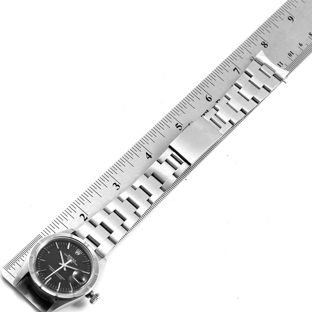This image shows the face and metal bracelet of a Rolex Vintage Collection 1501 Men
s Stainless Steel Black Dial 1501 Men
s Stainless Steel Black Dial watch next to a ruler for scale.