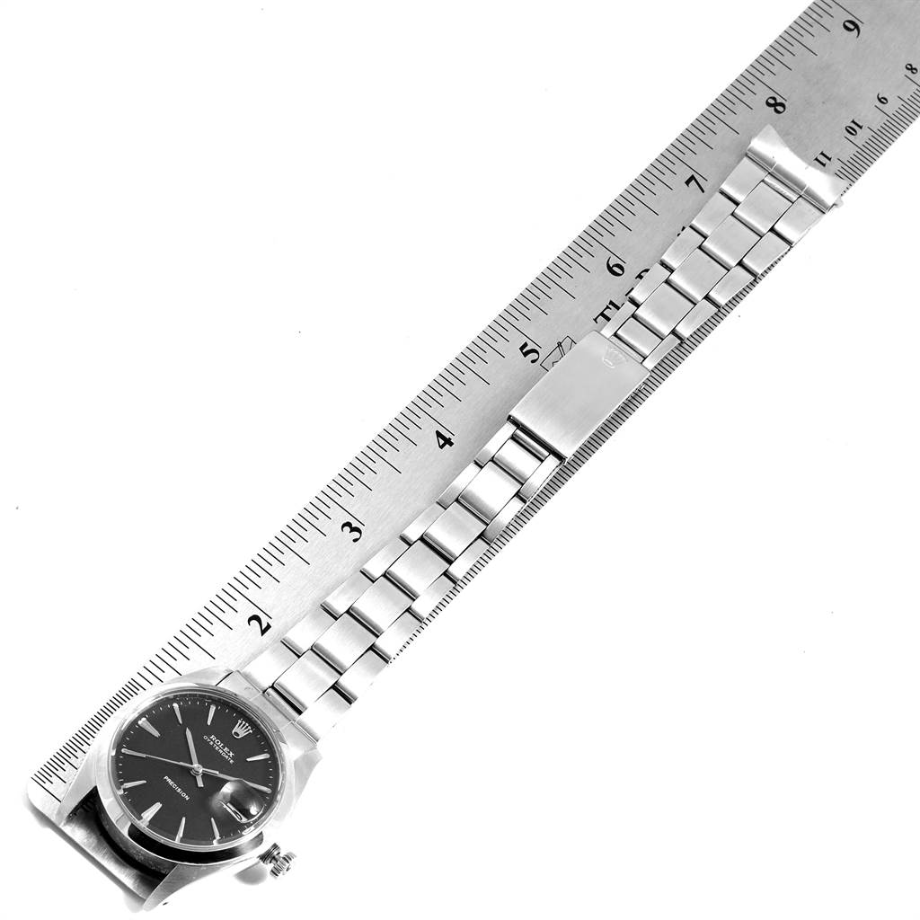The image shows a Rolex Vintage Collection 6694 Men's Stainless Steel Black Dial 6694 Men's Stainless Steel Black Dial watch placed alongside a ruler, displaying its face and metal bracelet from an overhead angle.