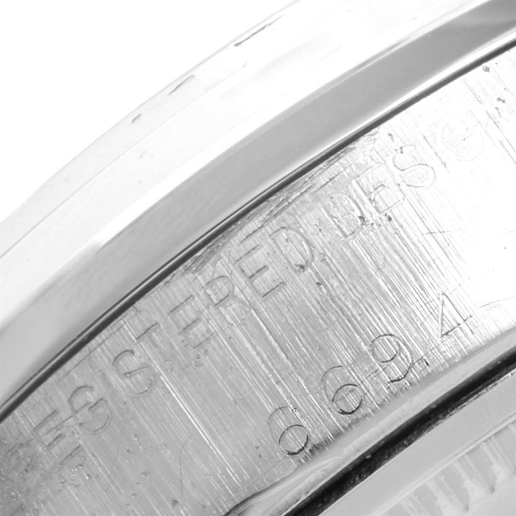This image shows an angled close-up of the side of a Rolex Vintage Collection 6694 Men's Stainless Steel Black Dial 6694 Men's Stainless Steel Black Dial watch case, highlighting the engravings.