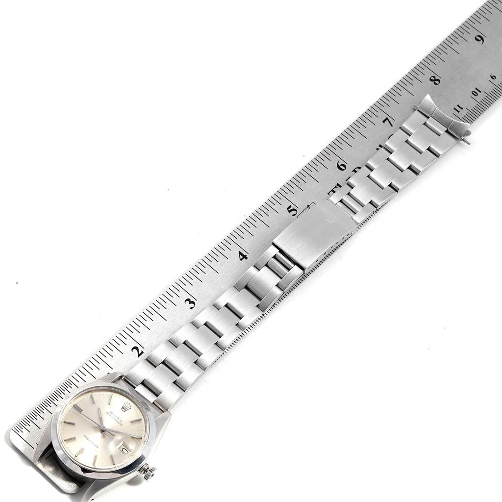 The Vintage Collection Rolex watch is shown from a top-down angle alongside a ruler, displaying the dial and entire band.