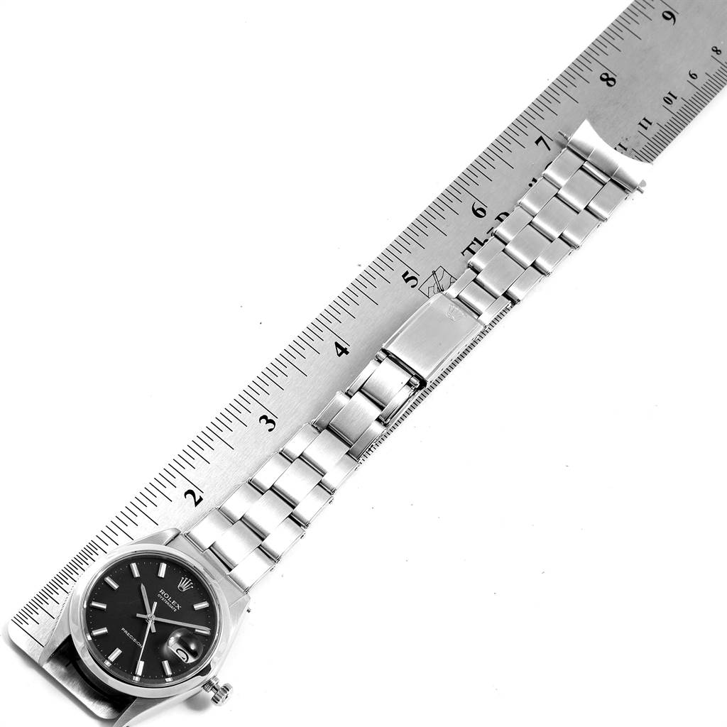 The image shows a top-down view of the Rolex Vintage Collection 6694 Men's Stainless Steel Black Dial 6694 Men's Stainless Steel Black Dial watch with its bracelet laid out next to a ruler for measurement.