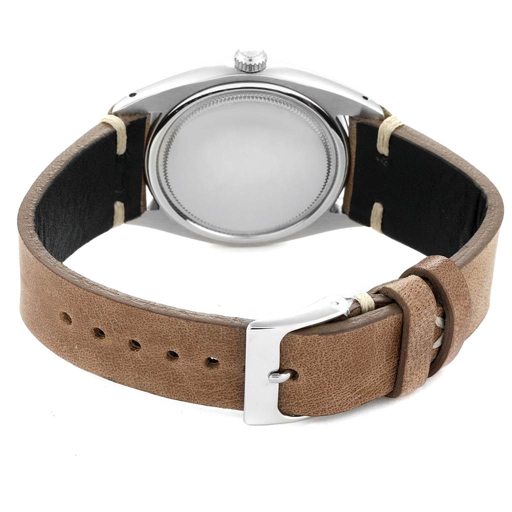 The image shows the back view of a Rolex Vintage Collection 6694 Men's Stainless Steel Champagne Dial 6694 Men's Stainless Steel Champagne Dial watch with its leather strap and buckle visible.