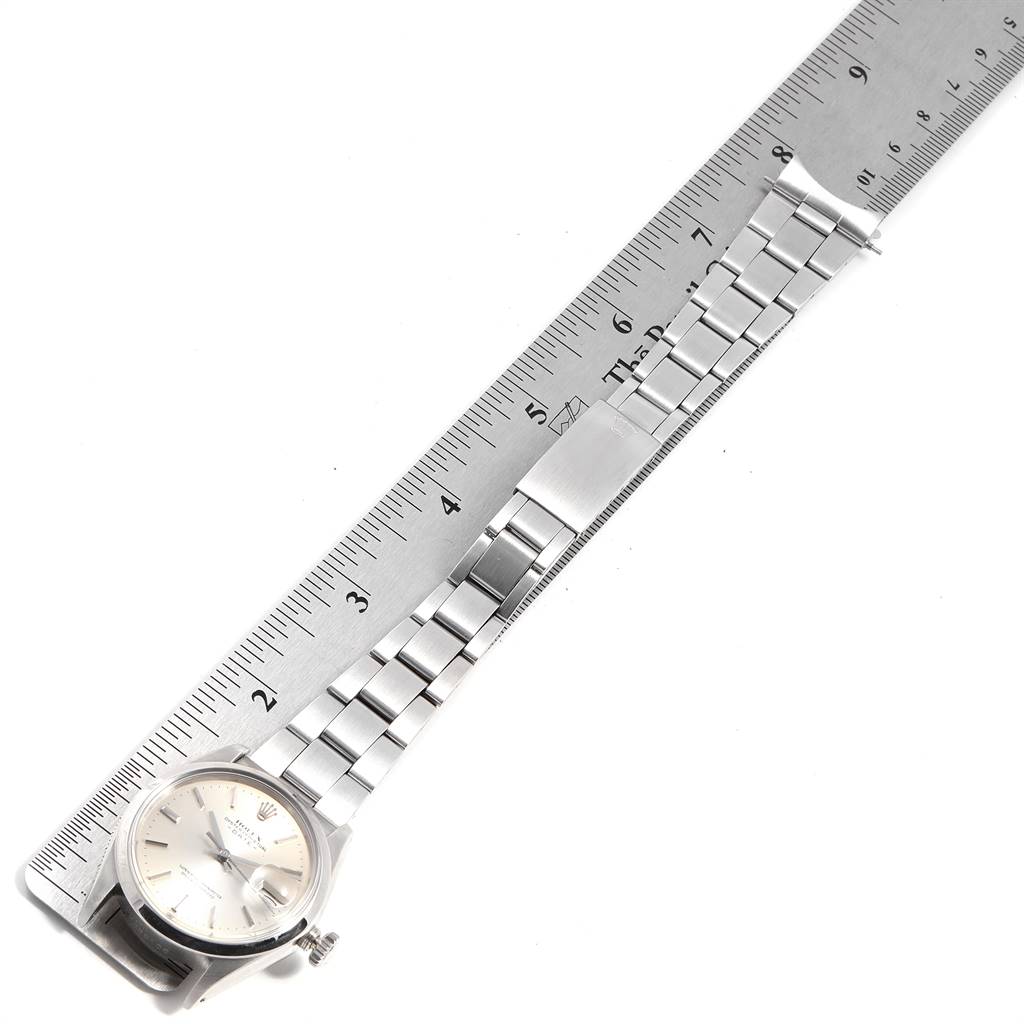 The watch, a Rolex Vintage Collection 1500 Men's Stainless Steel Silver Dial 1500 Men's Stainless Steel Silver Dial model, is shown from the top with its bracelet stretched next to a ruler.