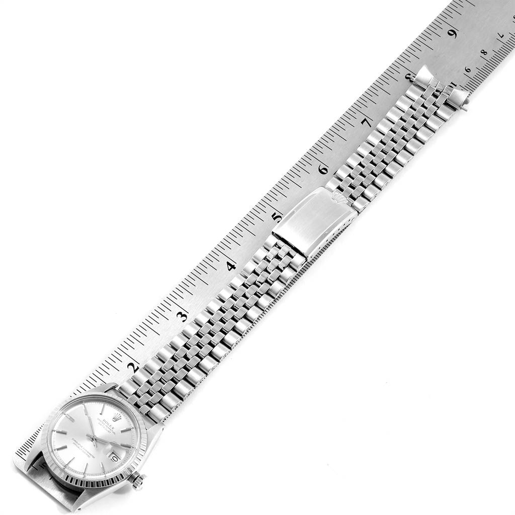 The image shows a top-down view of a Rolex Vintage Collection 1603 Men's Stainless Steel Silver Dial 1603 Men's Stainless Steel Silver Dial watch, highlighting its face, bezel, and metal bracelet against a ruler.