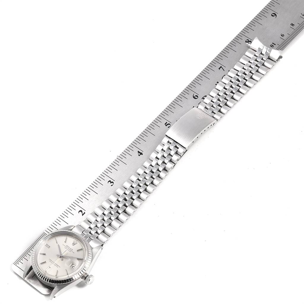 The Rolex Vintage Collection 1601 Men's Stainless Steel Silver Dial 1601 Men's Stainless Steel Silver Dial watch is shown from a top-down angle alongside a ruler, displaying its face and metal bracelet.