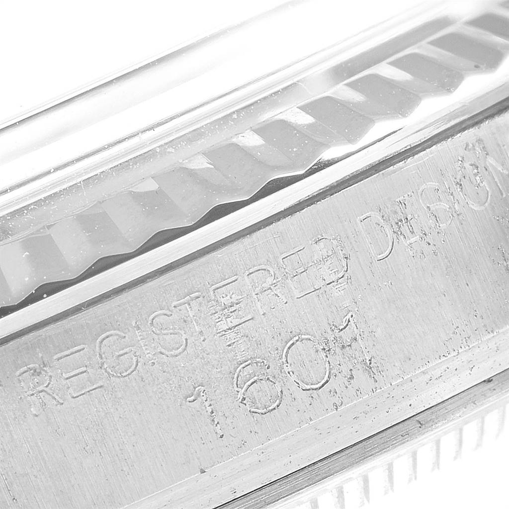 This close-up image shows the engraved text and part of the fluted bezel of the Vintage Collection Rolex watch model 1601.