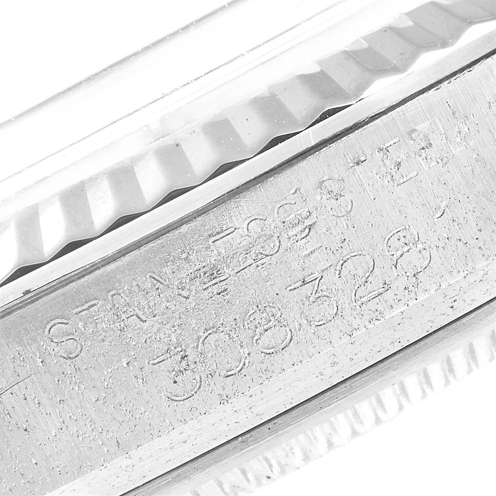This image shows a close-up view of the engraved serial number and part of the bezel of a Rolex Vintage Collection 1601 Men's Stainless Steel Silver Dial 1601 Men's Stainless Steel Silver Dial model watch.