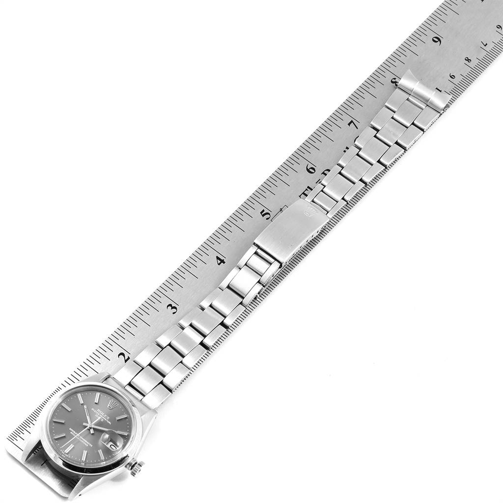The Rolex Vintage Collection 1500 Men's Stainless Steel Grey Dial 1500 Men's Stainless Steel Grey Dial watch is shown from a top-down angle, displaying its face and entire bracelet against a ruler for scale.