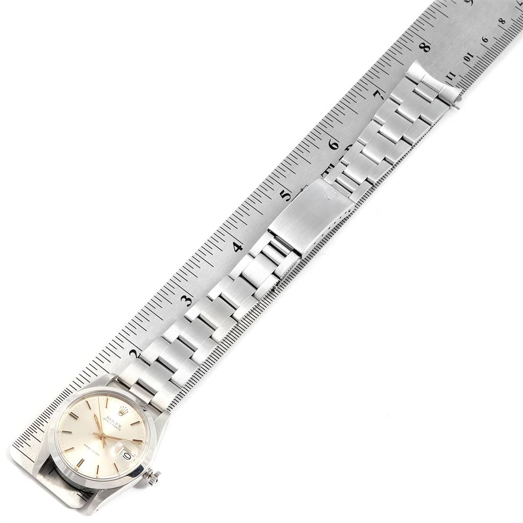 The Rolex Vintage Collection 6694 Men's Stainless Steel Silver Dial 6694 Men's Stainless Steel Silver Dial watch is shown from a top-down angle, displaying the face and metal bracelet aligned with a ruler.