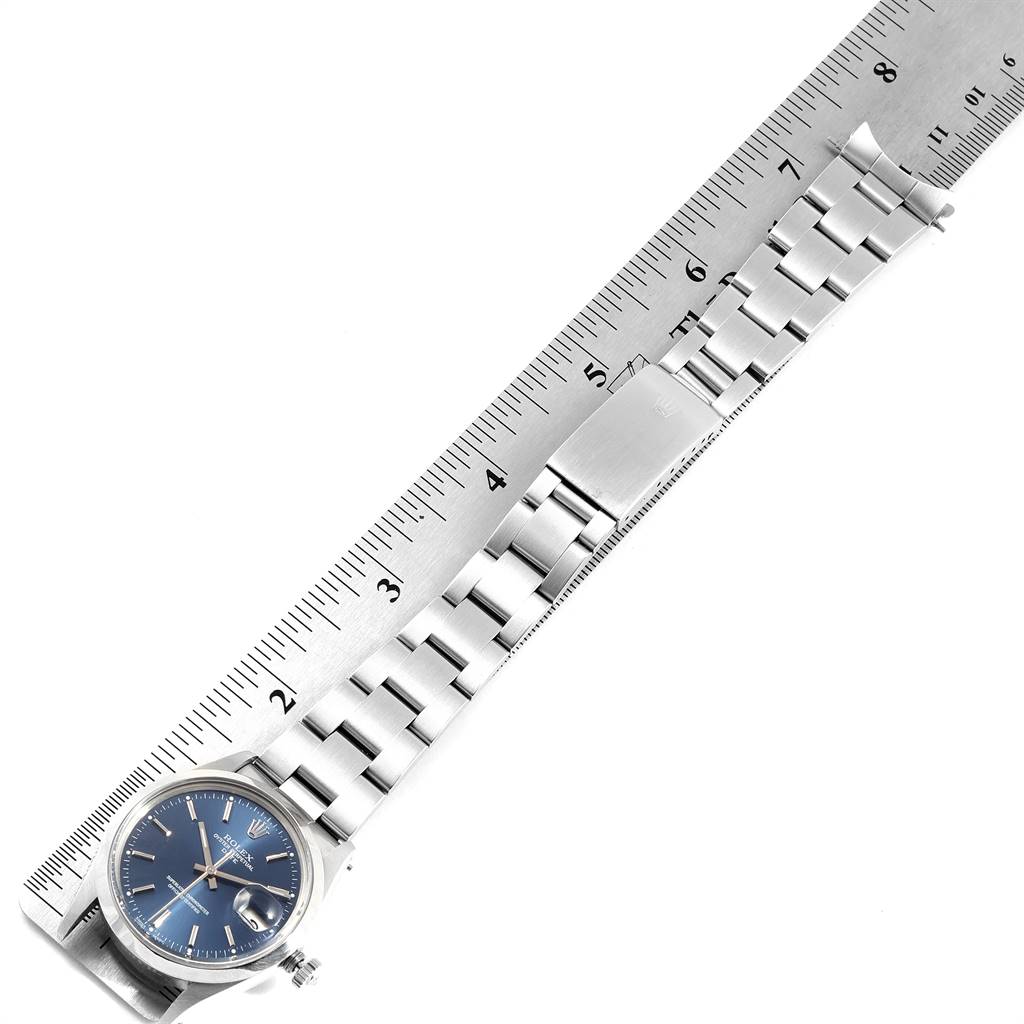 The image shows a Rolex Vintage Collection 15000 Men's Stainless Steel Blue Dial 15000 Men's Stainless Steel Blue Dial watch, displaying its face, bracelet, and clasp placed beside a ruler.