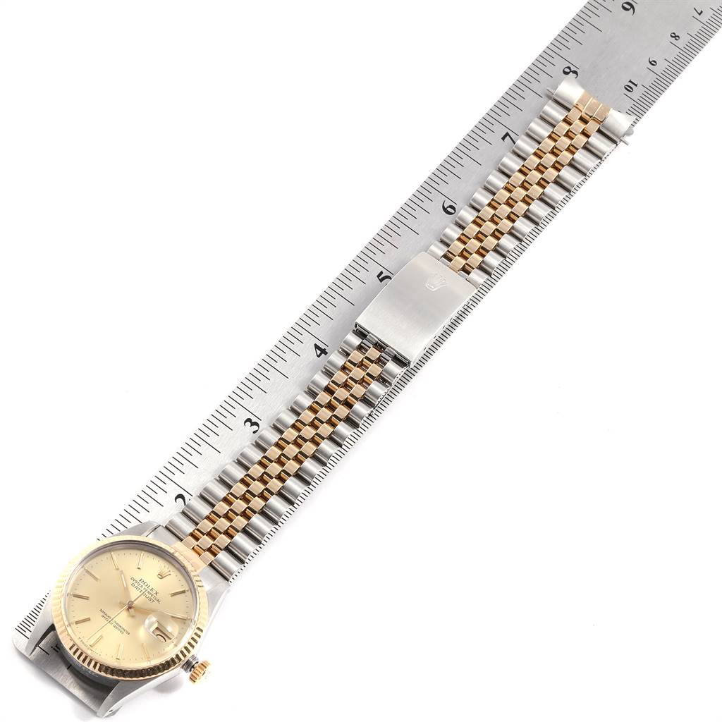 The Rolex Vintage Collection 16013 Men's Stainless Steel Champagne Dial 16013 Men's Stainless Steel Champagne Dial model watch is shown from a top-down angle, highlighting its face, bezel, and bracelet against a ruler.