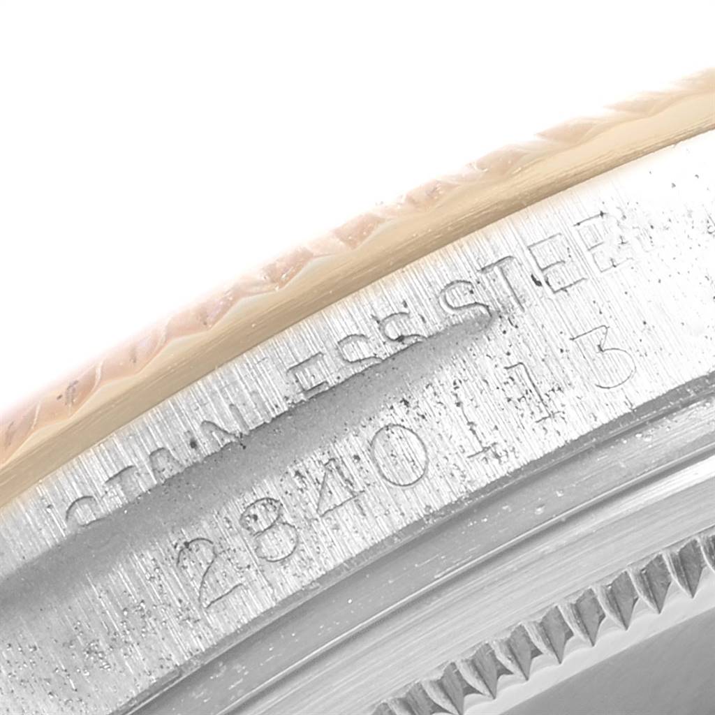 This close-up image shows the engraved serial number on the bezel of a Vintage Collection Rolex watch.