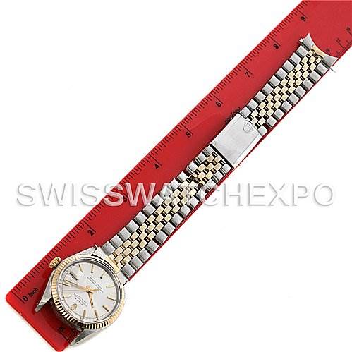 The image shows a top-down view of a Rolex Vintage Collection 1601 Men's Stainless Steel Silver Dial 1601 Men's Stainless Steel Silver Dial watch, featuring its dial, bezel, and two-tone bracelet extended alongside a ruler.