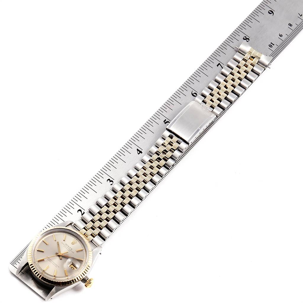 The image shows a Rolex Vintage Collection 1601 Men
s Steel and Gold (two tone) Silver Dial 1601 Men
s Steel and Gold (two tone) Silver Dial watch from a top-down angle with the dial and full bracelet placed alongside a ruler.