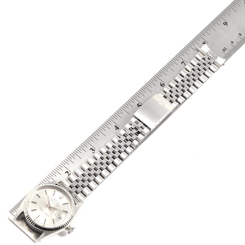 The image shows a top-down view of a Rolex Vintage Collection 1601 Men's Stainless Steel Silver Dial 1601 Men's Stainless Steel Silver Dial watch, displaying its face and metal bracelet alongside a ruler.