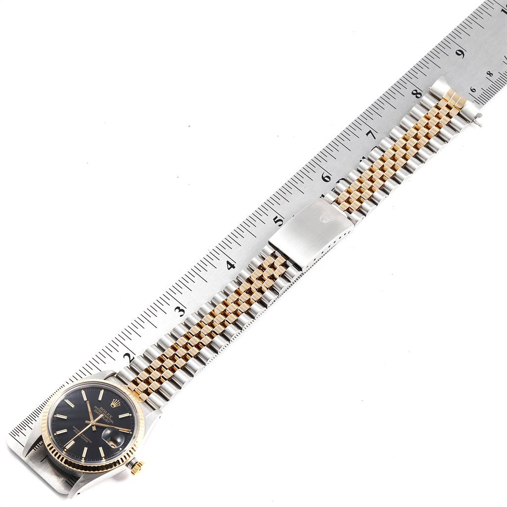 The image shows a Rolex Vintage Collection 16013 Men's Stainless Steel Black Dial 16013 Men's Stainless Steel Black Dial watch laid flat next to a ruler, revealing its black dial and two-tone metal bracelet.