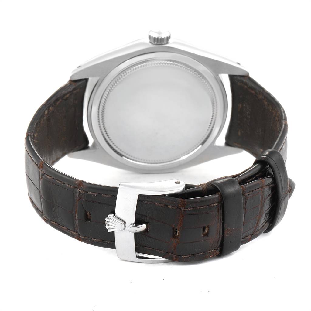 The image shows the back of a Rolex Vintage Collection 6694 Men's Stainless Steel Silver Dial 6694 Men's Stainless Steel Silver Dial watch and its leather strap with buckle.