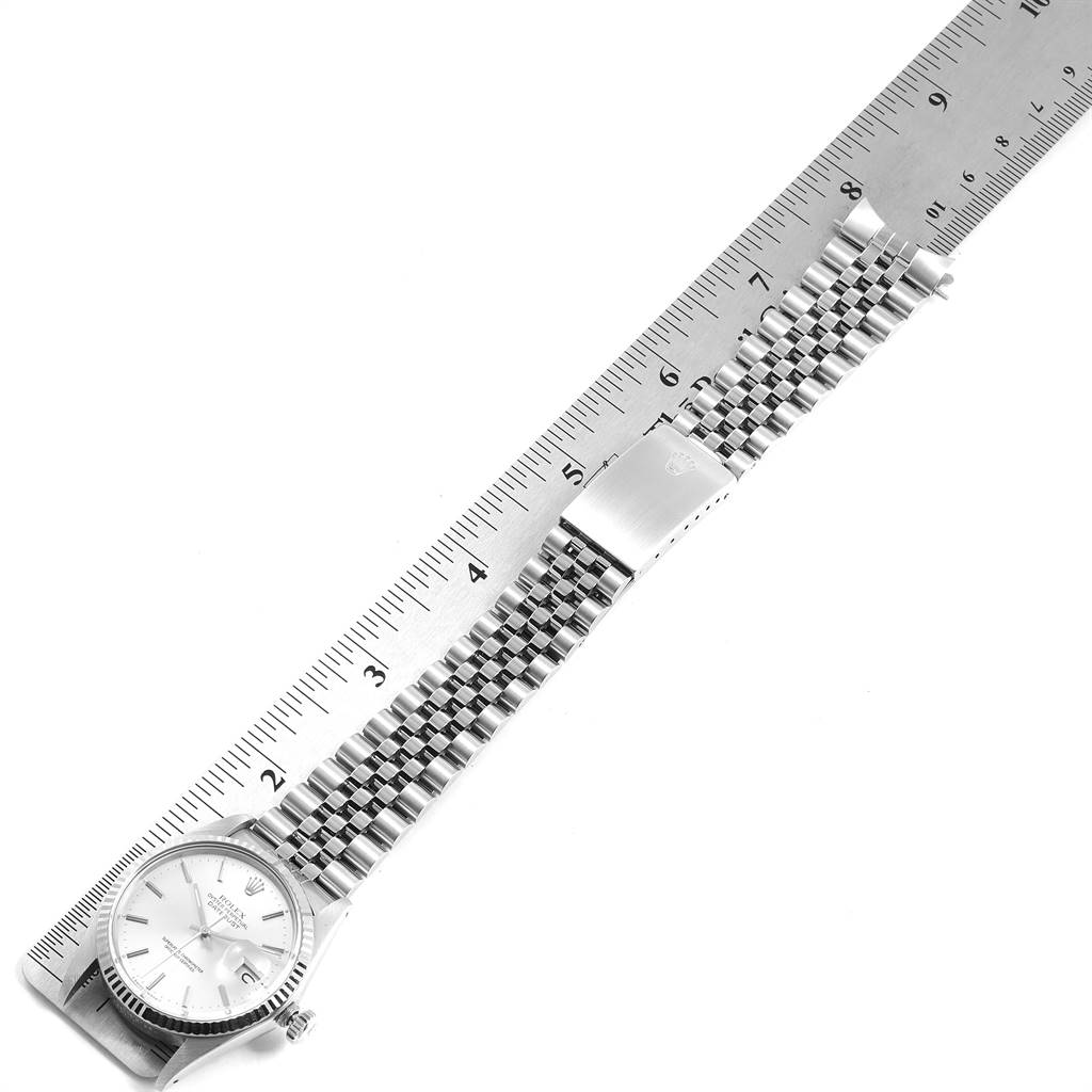 This image shows a Rolex Vintage Collection 16014 Men's Stainless Steel Silver Dial 16014 Men's Stainless Steel Silver Dial watch laid flat beside a ruler, highlighting its bracelet and clasp.