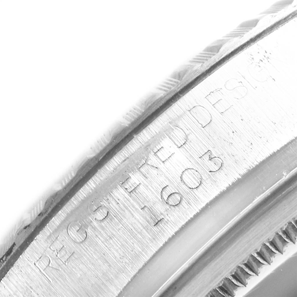 This close-up image shows the engraved serial number and part of the bezel of a Rolex Vintage Collection 1603 Men's Stainless Steel Silver Dial 1603 Men's Stainless Steel Silver Dial model watch.