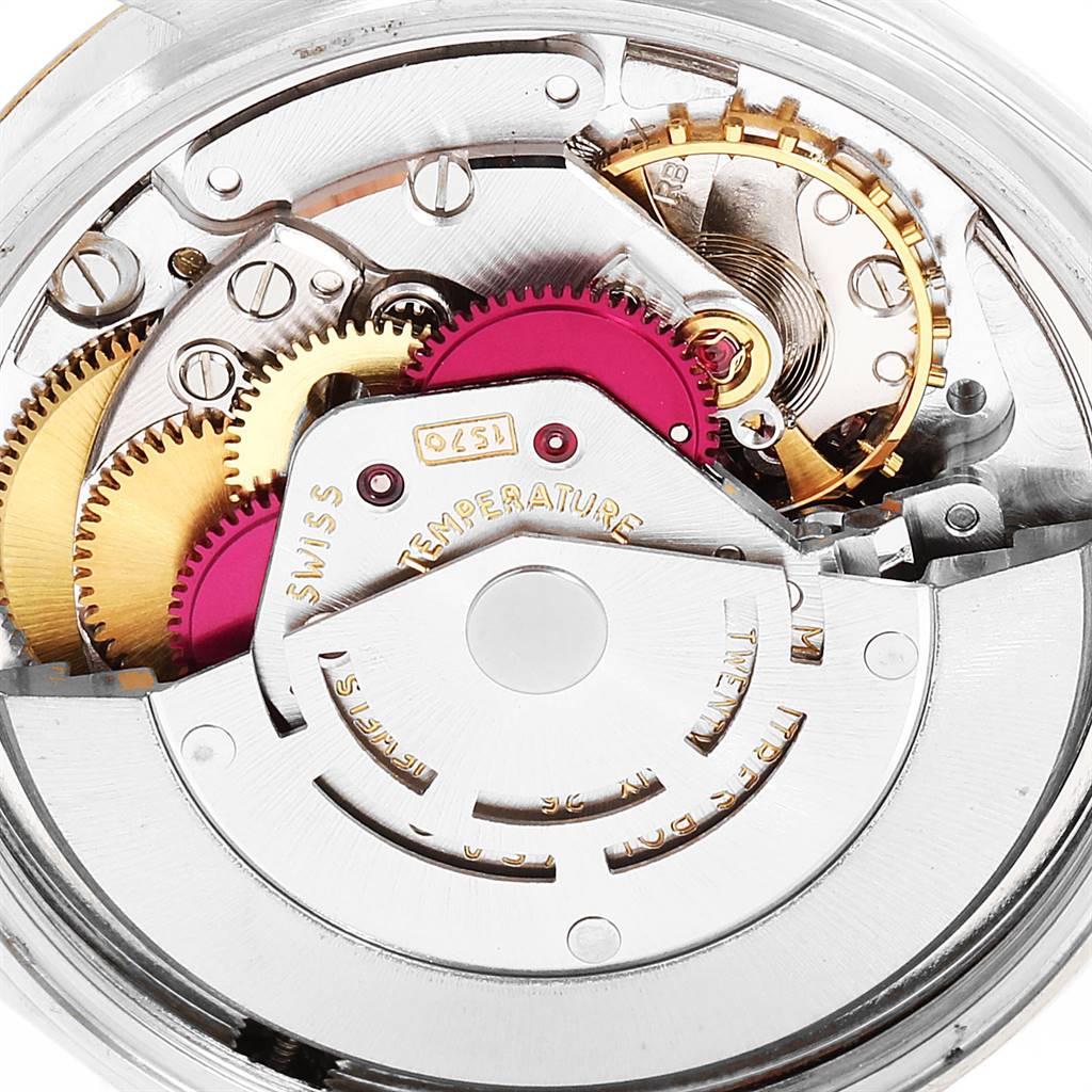 The image shows a close-up view of the internal mechanical components of a Vintage Collection Rolex watch, featuring gears and movement parts.