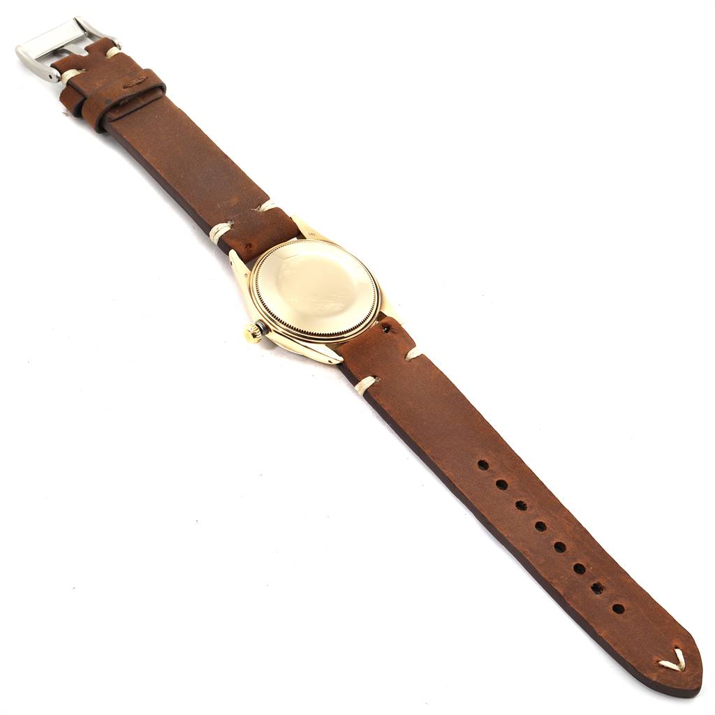 The image shows a Vintage Collection Rolex watch, viewed from the back, displaying its brown leather strap and case back.