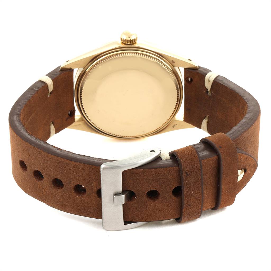 The image shows the back view of a Rolex Vintage Collection 1503 Men's Yellow Gold Silver Dial 1503 Men's Yellow Gold Silver Dial watch, highlighting its caseback and leather strap with a buckle.