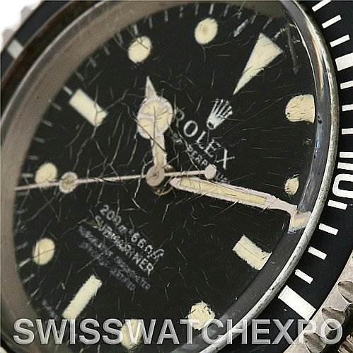 The image shows a close-up of the cracked dial and hands of a Vintage Collection Rolex Submariner watch.