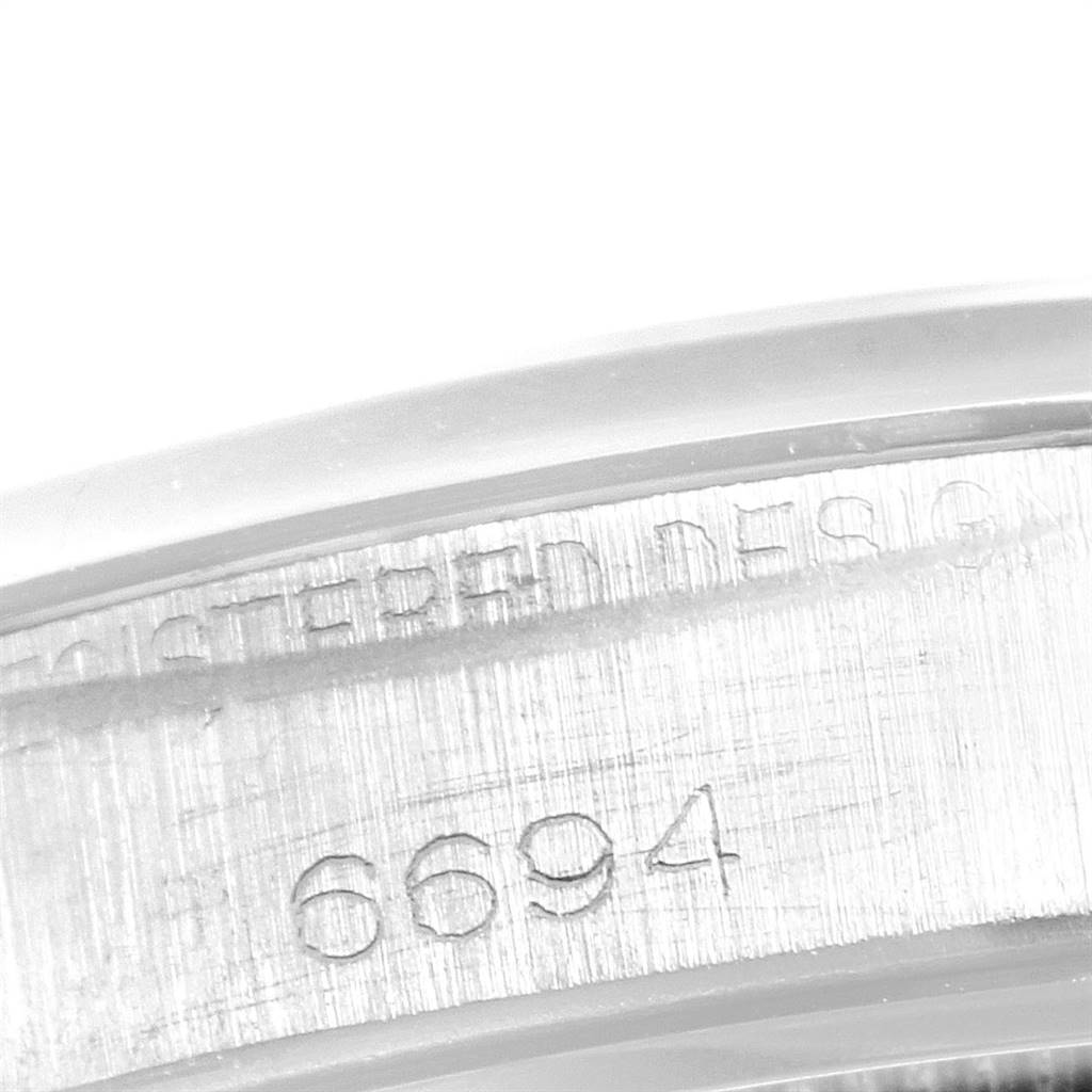 The image captures a close-up view of the side of the case of the Rolex Vintage Collection 6694 Men
s Stainless Steel Silver Dial 6694 Men
s Stainless Steel Silver Dial model, showing the engraved serial number "6694."