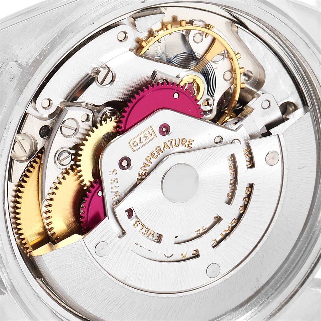 The image shows a close-up view of the inner mechanism of a Vintage Collection Rolex watch, highlighting gears and components.