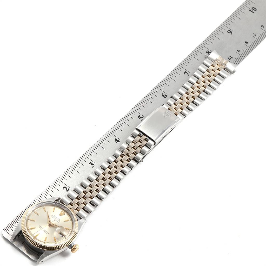 The Vintage Collection Rolex watch is shown from the top view, highlighting its dial, bracelet, and clasp, alongside a ruler.