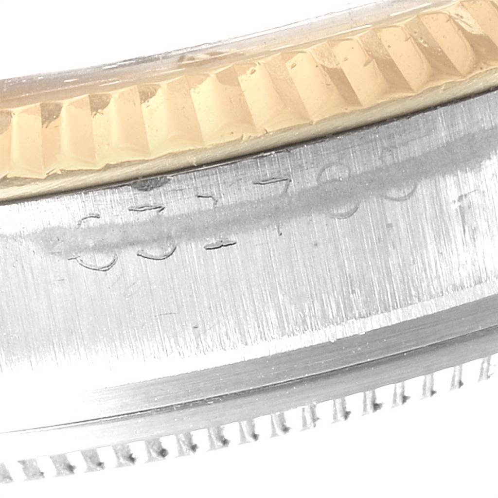 This close-up image shows the side view of the bezel and case with an engraved serial number of the Rolex Vintage Collection 1601 Men's Steel and Gold (two tone) Silver Dial 1601 Men's Steel and Gold (two tone) Silver Dial watch.