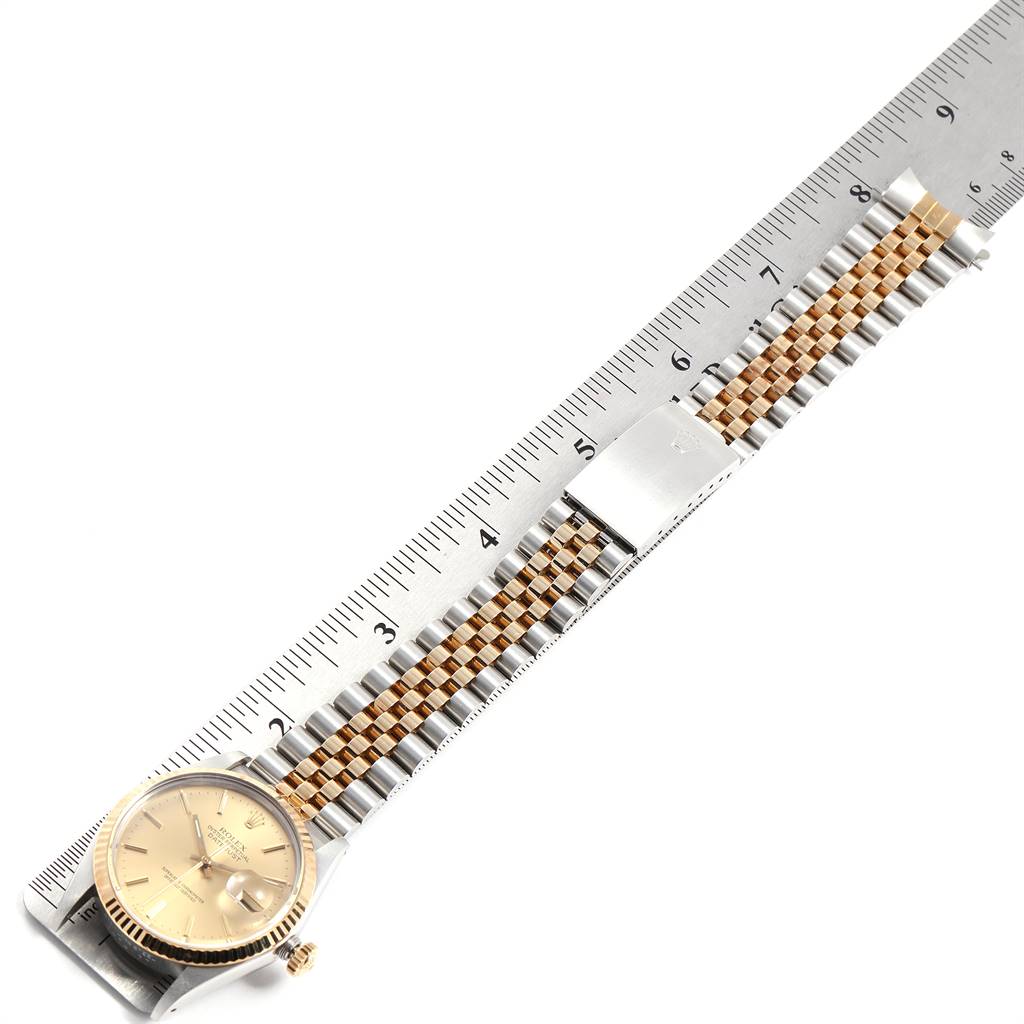 The image shows a Vintage Collection Rolex watch laid flat on a ruler, displaying its gold dial, two-tone bracelet, and clasp.