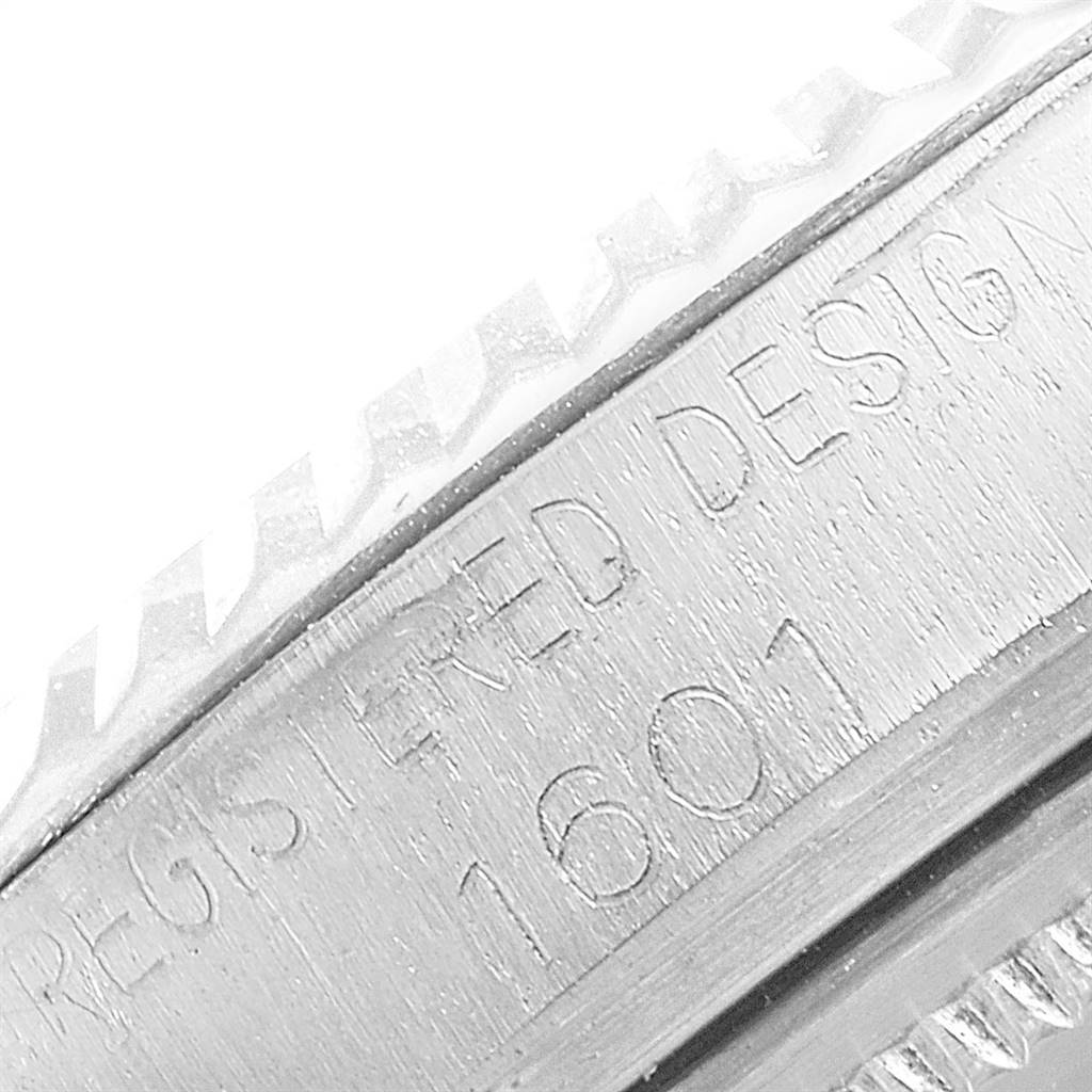 The image shows a close-up of the engraved casing and fluted bezel of a Vintage Collection Rolex Model 1601.