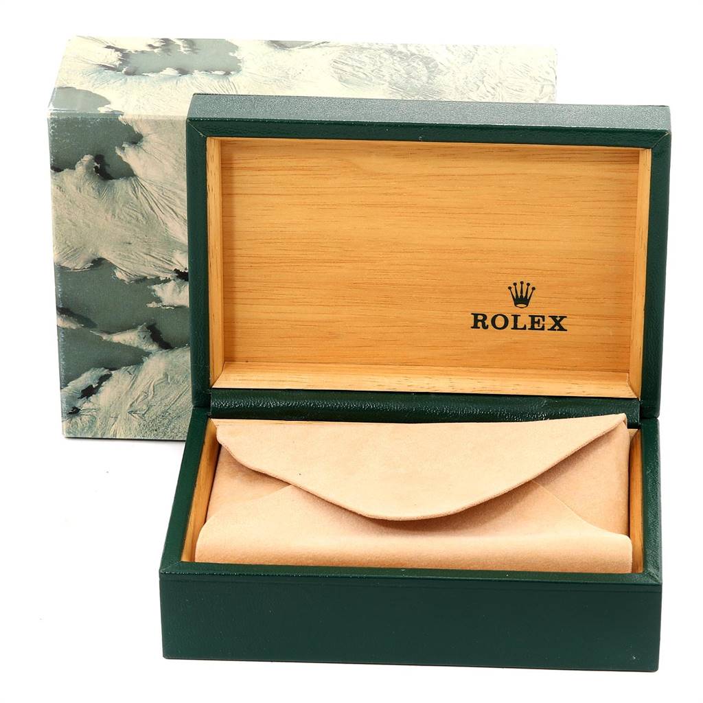 This image shows an open green Rolex watch box from the Vintage Collection model, featuring interior branding and a cream pouch.