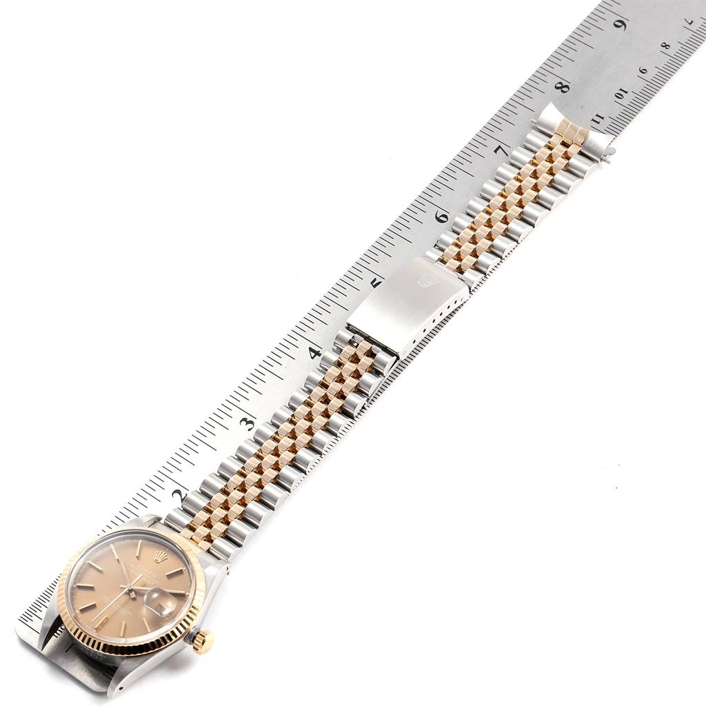 The image shows a Rolex Vintage Collection 16013 Men's Stainless Steel Brown Dial 16013 Men's Stainless Steel Brown Dial watch laid flat with its gold and silver bracelet alongside a ruler.