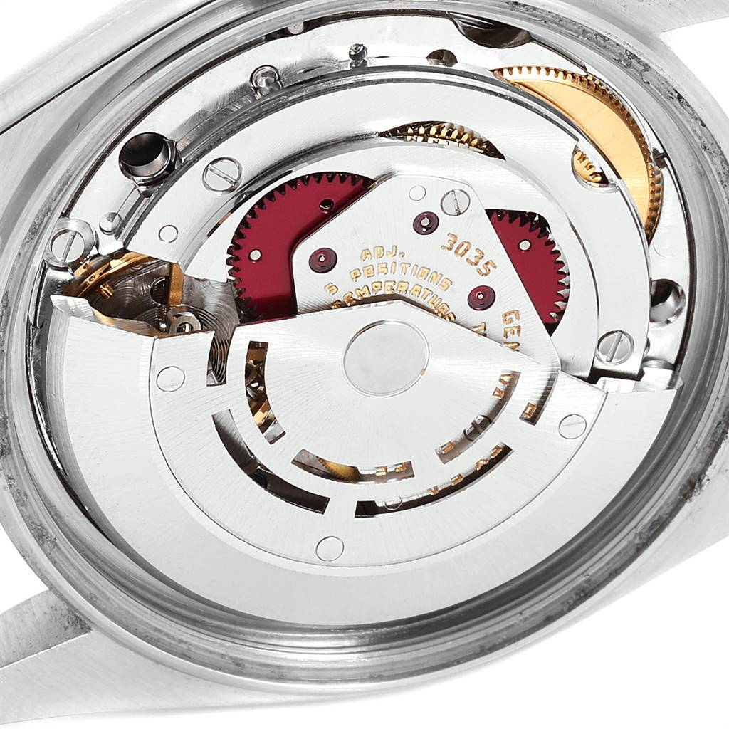 The image shows a close-up of the movement inside a Vintage Collection model by Rolex, revealing gears and the rotor.