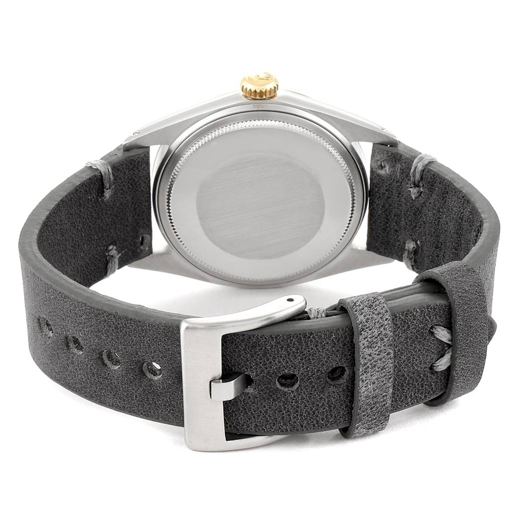 The image shows the back view of a Rolex Vintage Collection 1601 Men's Steel and Gold (two tone) Grey Dial 1601 Men's Steel and Gold (two tone) Grey Dial watch, highlighting its case back, crown, and leather strap with buckle.