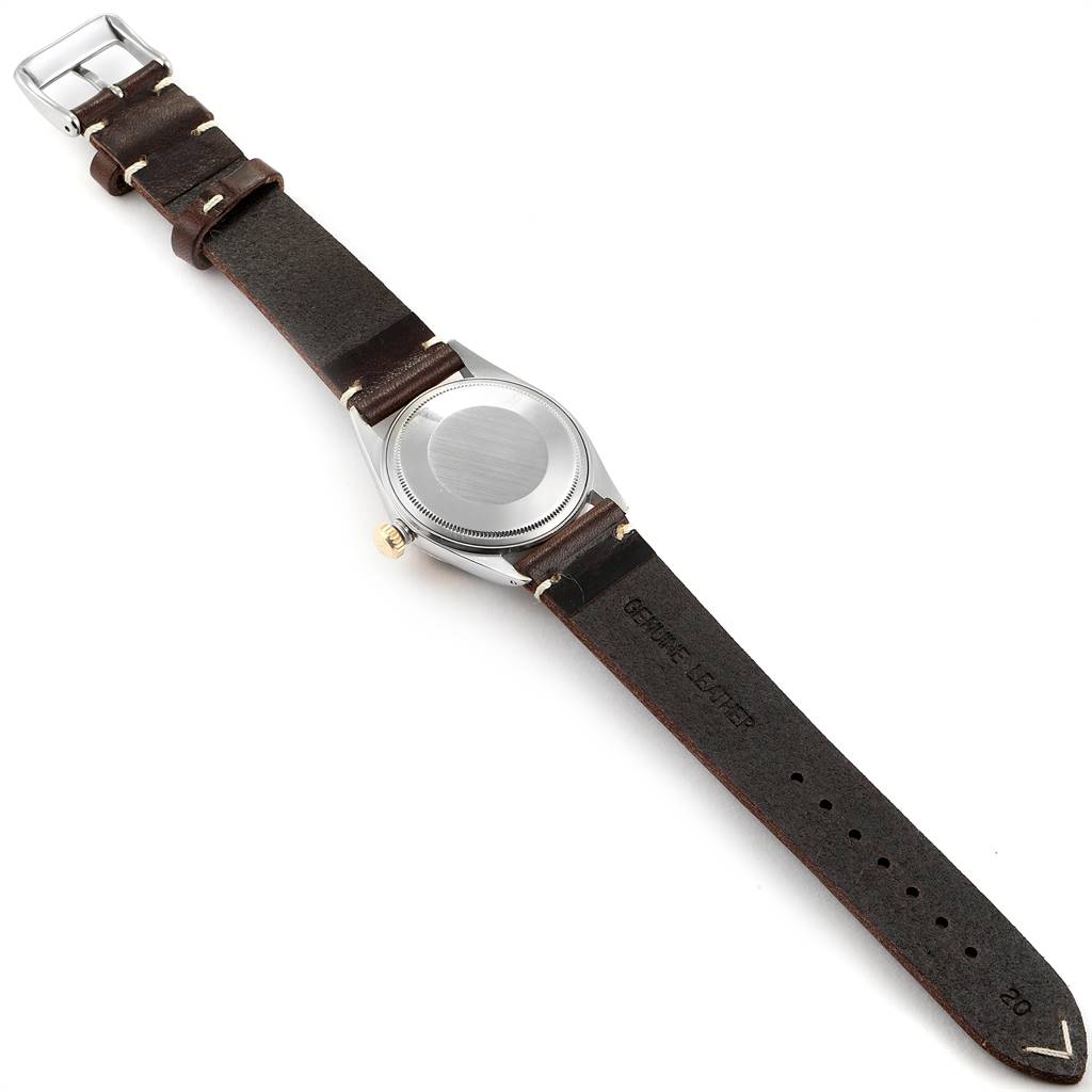 The image shows the backside of a Rolex Vintage Collection 1601 Men
s Steel and Gold (two tone) Blue Dial 1601 Men
s Steel and Gold (two tone) Blue Dial watch with a brown leather strap.