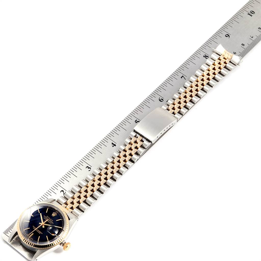 The Vintage Collection Rolex watch is shown flat, displaying the dial, bracelet, and clasp alongside a ruler.