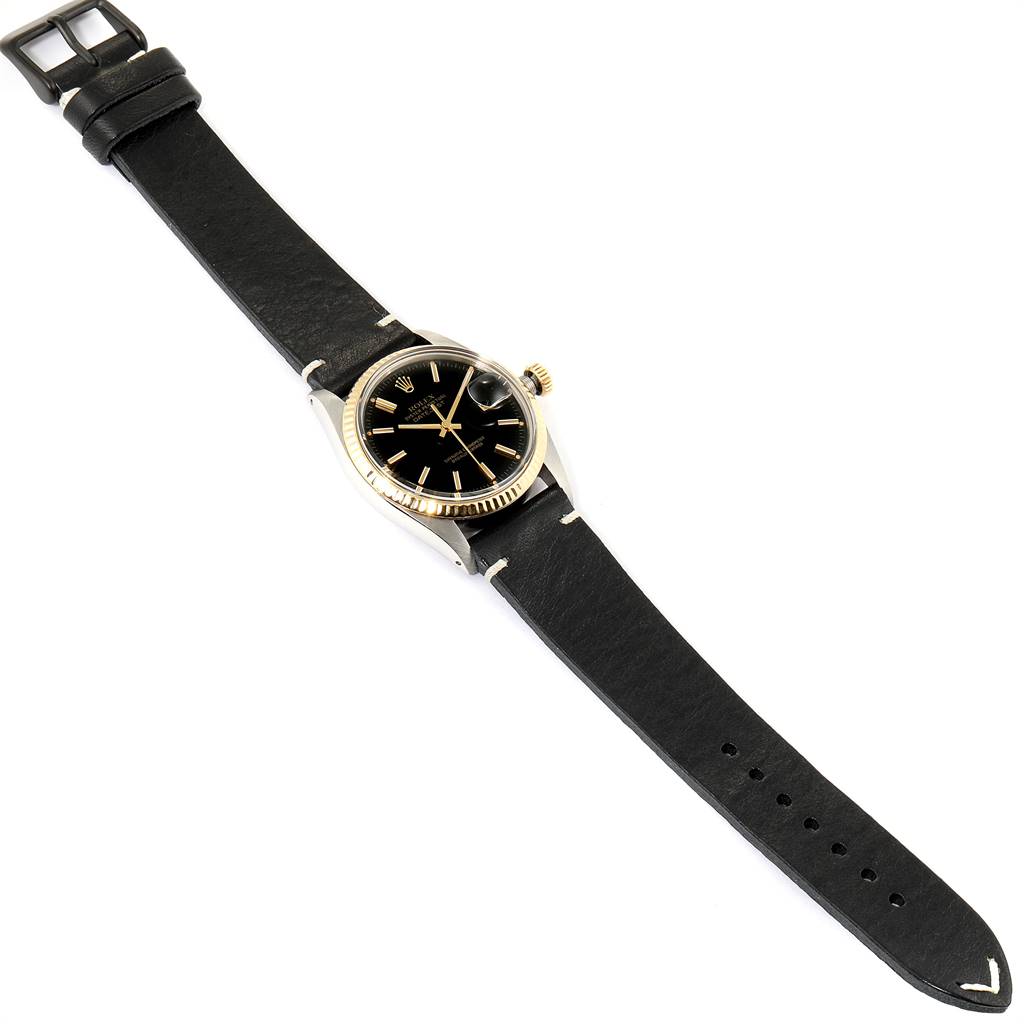 The Rolex Vintage Collection 16013 Men
s Stainless Steel Black Dial 16013 Men
s Stainless Steel Black Dial watch is shown from a top-down angle, featuring a black leather strap, black dial, and gold bezel.