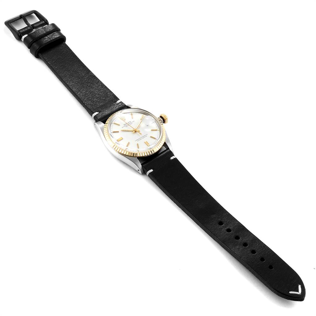 The Vintage Collection Rolex watch is shown from a top-down angle, displaying its full face, leather strap, and buckle.