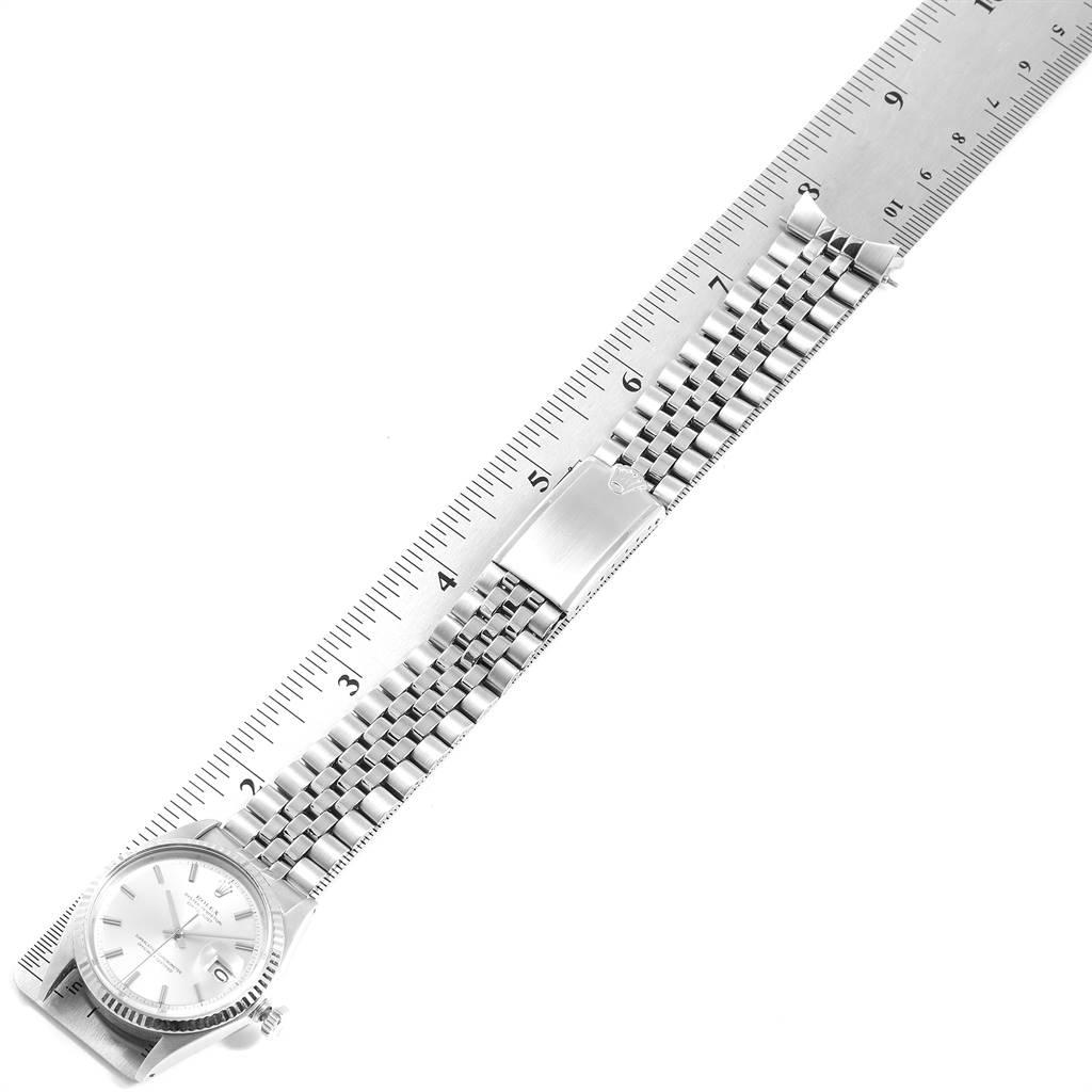 The image shows a Rolex Vintage Collection 1601 Men
s Stainless Steel Silver Dial 1601 Men
s Stainless Steel Silver Dial watch laid flat with the band extended next to a ruler.