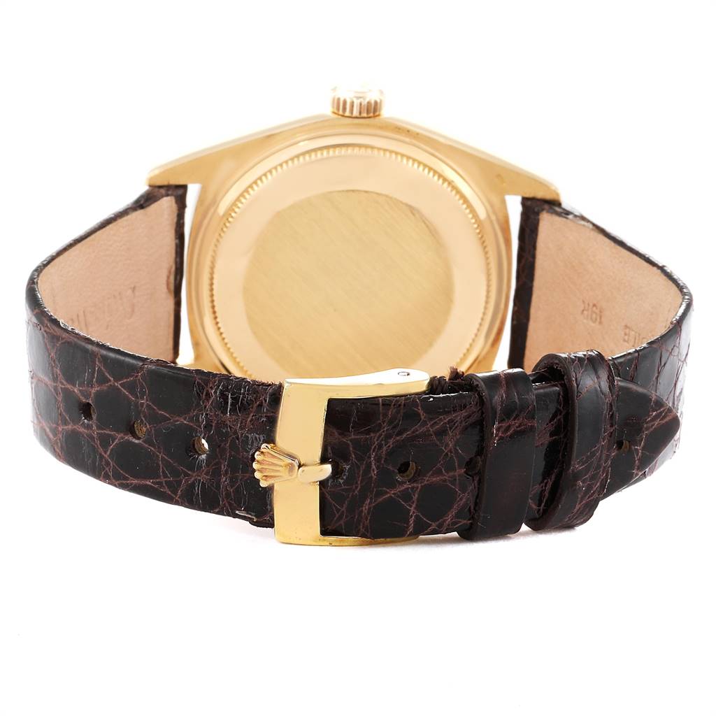 This image shows the back view of a Rolex Vintage Collection 1803 Men
s Yellow Gold Silver Dial 1803 Men
s Yellow Gold Silver Dial watch, highlighting its gold case and brown leather strap with buckle.