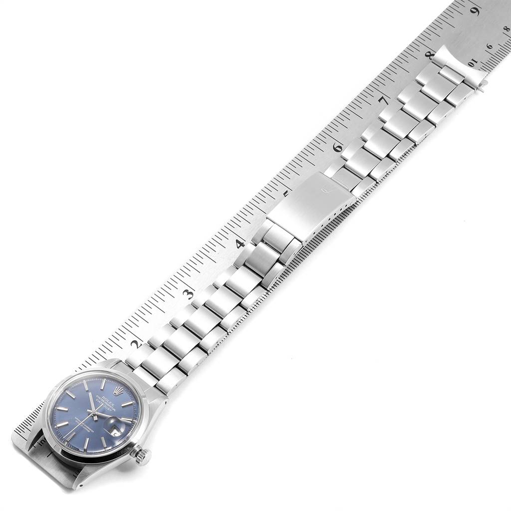 The image shows a Rolex Vintage Collection 1600 Men's Stainless Steel Blue Dial 1600 Men's Stainless Steel Blue Dial watch laying flat with a metal bracelet alongside a ruler for scale.